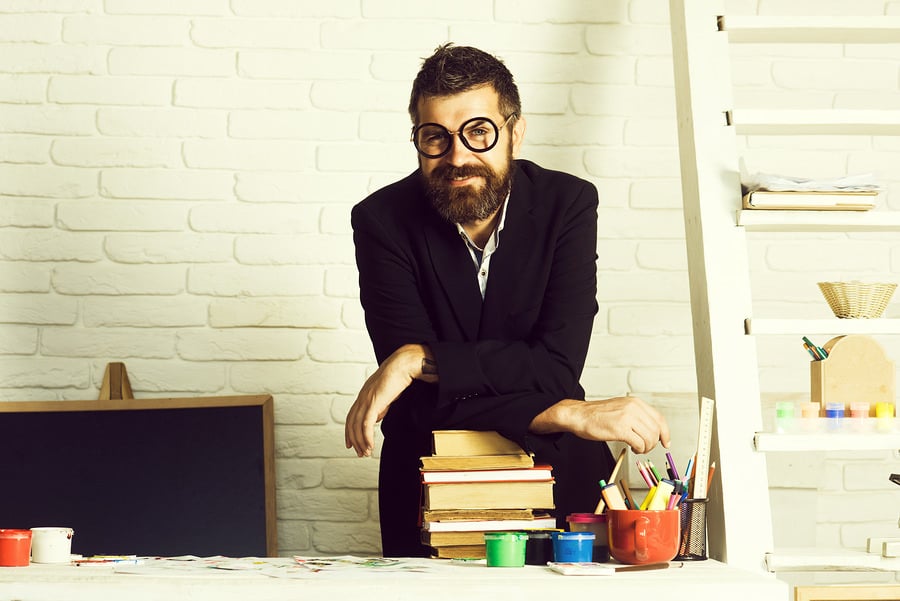 Smiling bearded young man working with a student in a classroom setting